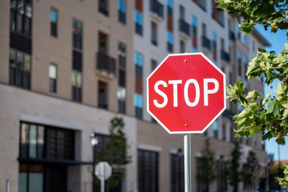 A stop sign on a sunny urban street